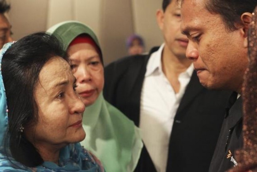 Rosmah Mansor (left), wife of Malaysian Prime Minister Najib Razak, cries with family members of passengers on the missing Malaysia Airlines flight MH370, at a hotel in Putrajaya March 9, 2014.