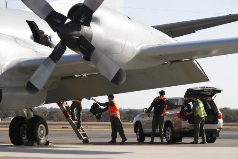Royal Australian Air Force (RAAF) AP-3C Orion crew members unload equipment after returning from a search for Malaysian Airlines flight MH370 over the Indian Ocean, at RAAF Base Pearce north of Perth, Australia, March 21, 2014.
