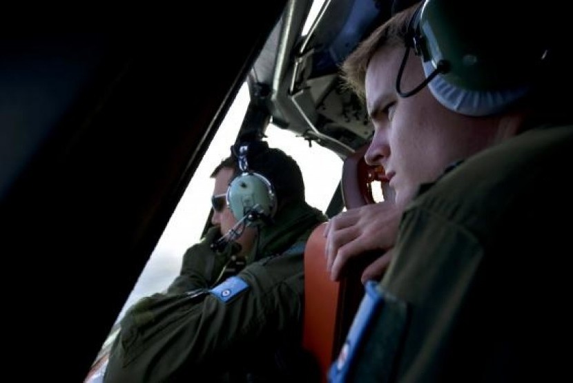 Royal Australian Air Force (RAAF) pilot Flight Lieutenant Joshua Williams (left) and Flying Officer Daniel Bailey look from the cockpit of an RAAF AP-3C Orion aircraft.
