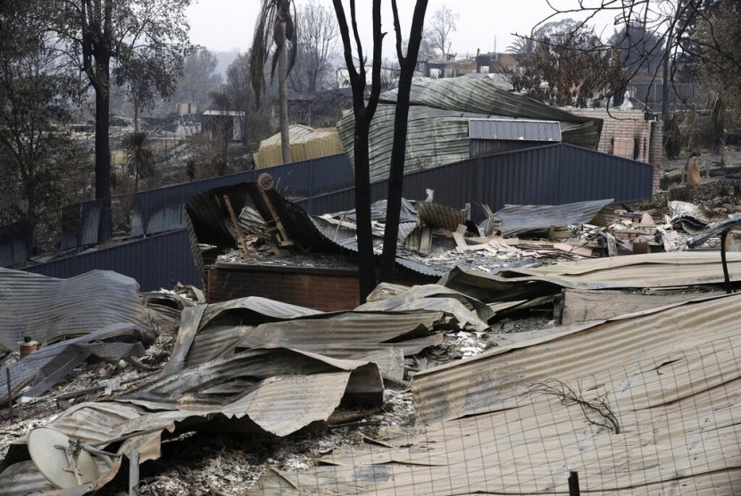 Rumah rusak akibat diterjang api di Conjola Park, Australia, Ahad (5/1). Hujan ringan pada hari kedua sedikit membantu memadamkan kebakaran hutan yang telah menewaskan 24 orang di seluruh Australia tenggara. 
