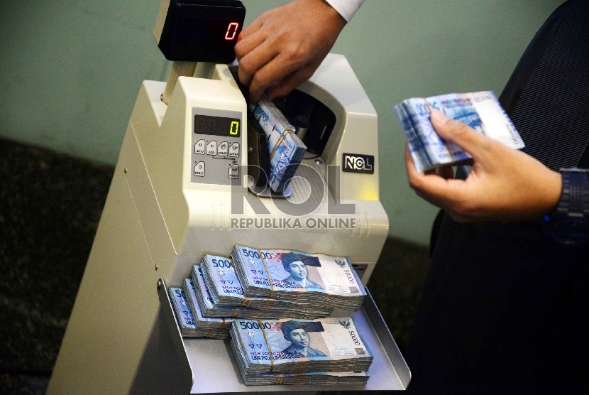 Rupiah Semakin Melemah: Teller menghitung uang rupiah di Banking Hall Bank Mandiri, Jakarta, Rabu (11/3).