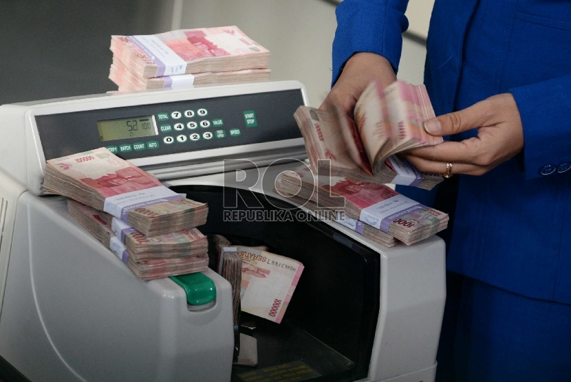 Rupiah Terus Merosot: Petugas menghitung uang rupiah dan dolar di salah satu penukaran uang di Jakarta, Kamis (5/3).