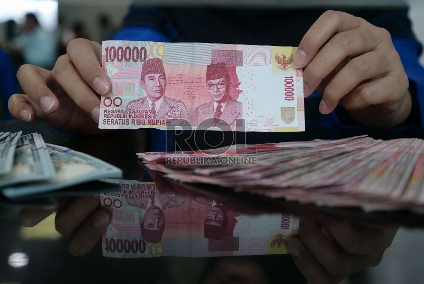 Rupiah Terus Merosot: Petugas menghitung uang rupiah dan dolar di salah satu penukaran uang di Jakarta, Kamis (5/3).