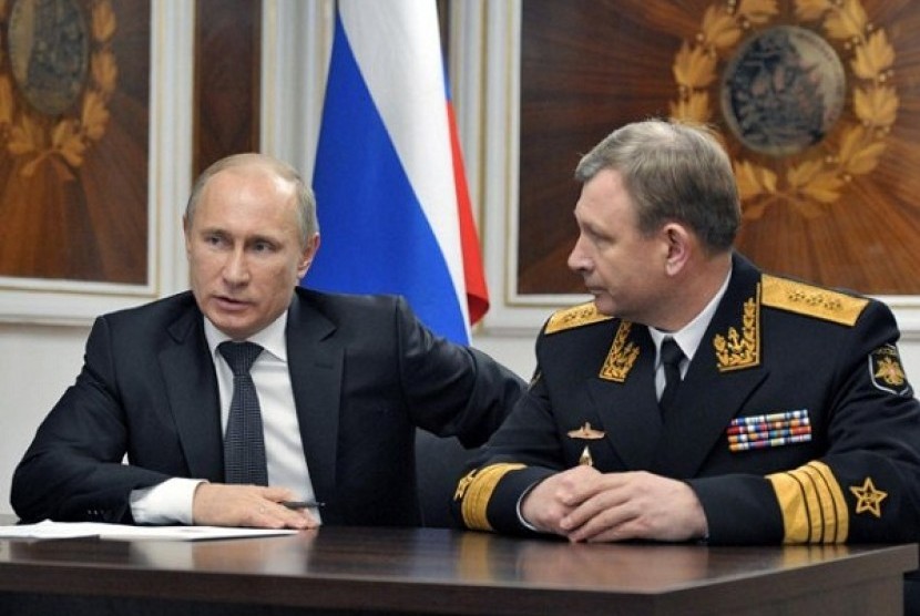 Russian President Vladimir Putin, left, and Russian Navy's commander-in-chief Viktor Chirkov, right, talk on board a navy ship in Severomorsk, Russia, on Thursday, Jan. 10, 2013.   