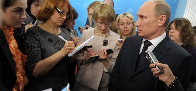 Russian Prime Minister Vladimir Putin, right, speaks during a meeting with reporters in Moscow, recently. 