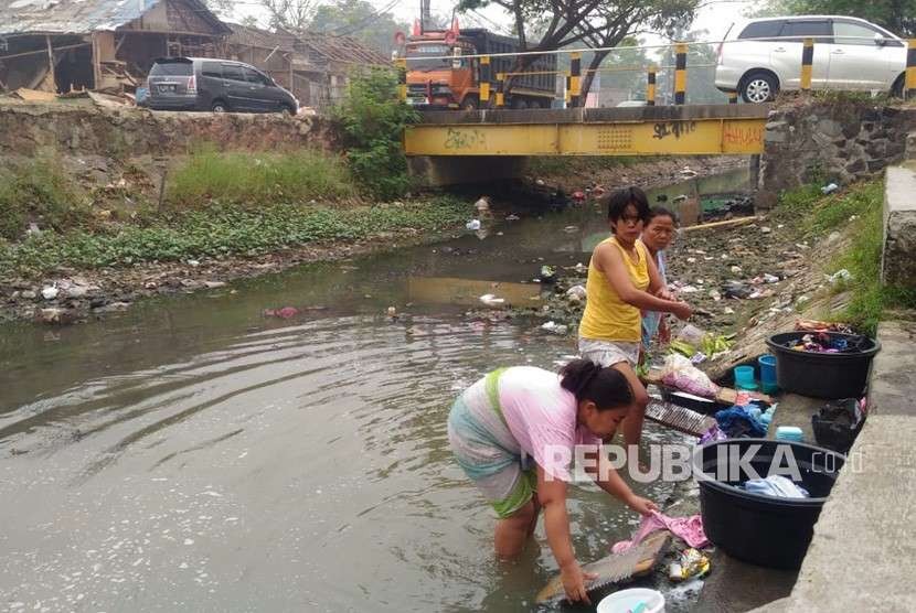 Rutinitas ibu-ibu mencuci di kali tepat di samping jalan raya, di tengah keterbatasan air bersih, Desa Teluk Naga, Kabupaten Tangerang, Rabu (8/8).