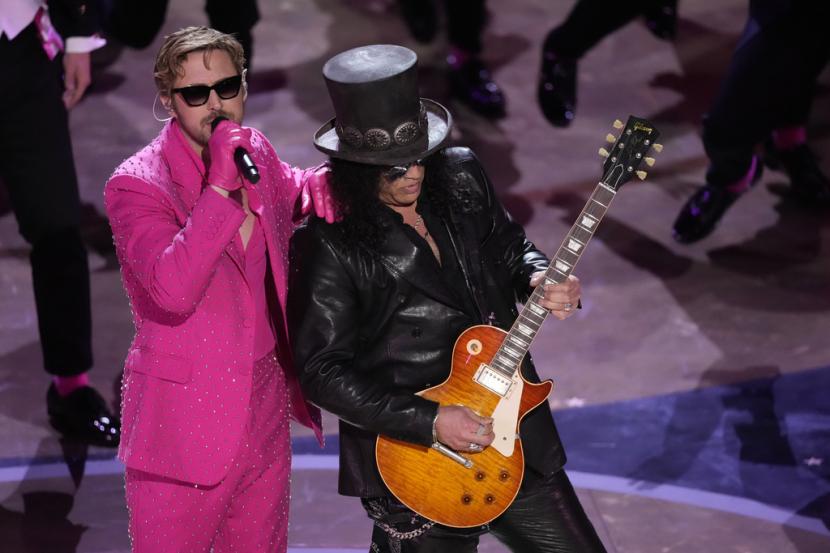 Ryan Gosling, kiri, membawakan lagu Im Just Ken dari film Barbie bersama Slash, kanan, bermain gitar saat penyerahan Oscar pada Minggu, 10 Maret 2024, di Dolby Theater di Los Angeles.