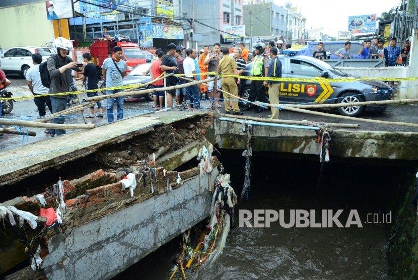 Salah satu bagian trotoar tinggal setengahnya akibat tergerus arus sungai, di Jl Pagarsih, Kota Bandung, Senin (24/10). Di lokasi tersebut satu buah motor dan mobil terbawa arus sungai dan belum ditemukan. (Republika/Edi Yusuf)
