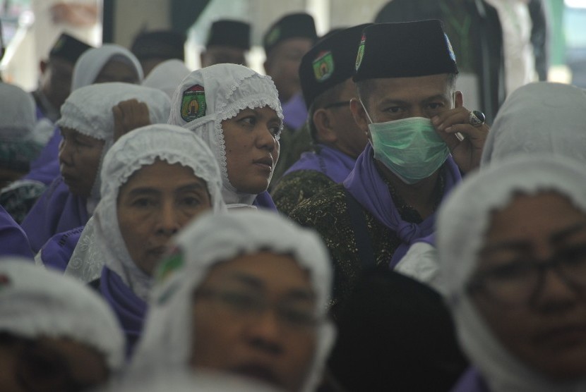 Salah satu calon haji embarkasi Palembang mengenakan masker sebagai salah satu perbekalan kesehatan jemaah haji di Aula Asrama Haji Palembang, Sumsel, Kamis (27/8). 