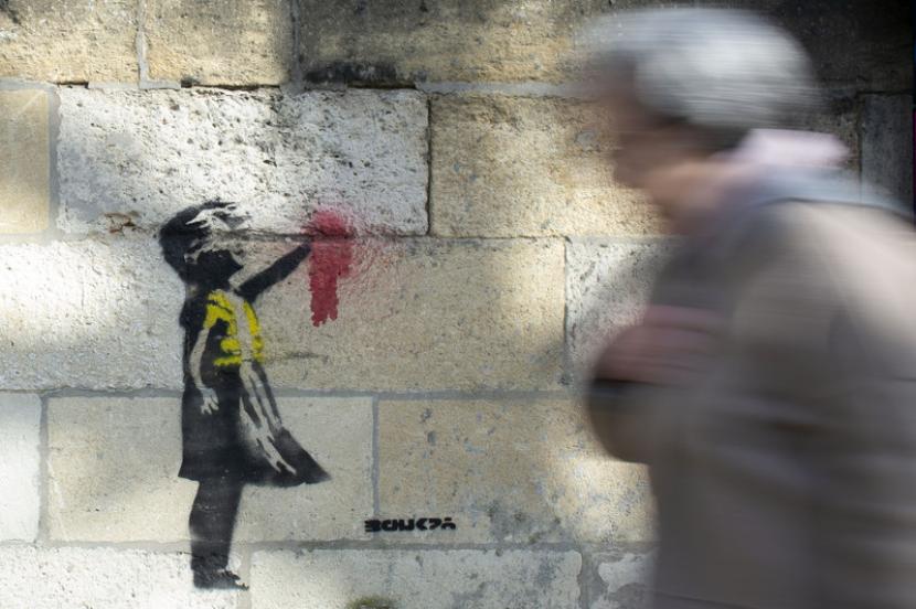 Salah satu karya Banksy kini nampak mengenakan masker berwarna biru. Ilustrasi