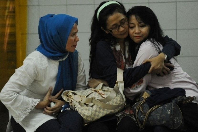 Salah satu keluarga korban hilangnya pesawat Sukhoi Super Jet 100 menenangkan anggota keluarga lainnya usai melihat daftar nama keluarganya termasuk dari 44 penumpang yang hilang di Bandara Halim Perdanakusuma, Jakarta, Rabu (9/5).