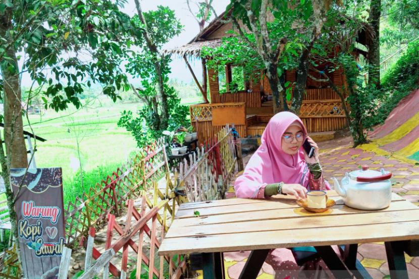 Salah satu pengunjung menikmati kopi di Warung Kopi Sawah di Solok, Sumatra Barat.