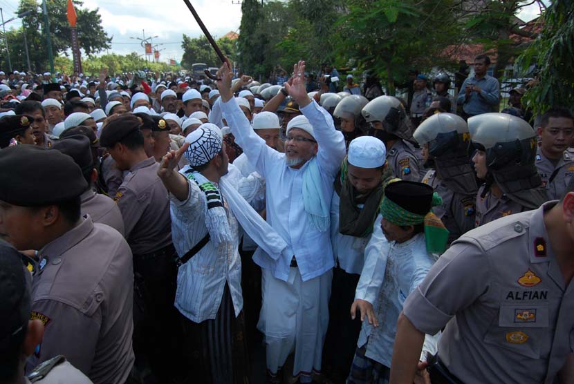   Salah satu tokoh Ulama Madura, menenangkan massa saat akan berusaha menerobos blokade Polisi, usai mengikuti istighasah terkait pengungsi Syiah, di Sampang, Jatim, Kamis (20/6).    (Antara/Saiful Bahri)