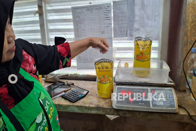 Salah Seorang Pedagang di Kota Cimahi, Jawa Barat Mengukur Minyak Goreng Kemasan MinyaKita. Disdagkoperind Kota Cimahi Menemukan Ada Minyak Goreng Kemasan yang Takarannya Dibawah 1 Liter Beredar di Pasaran.