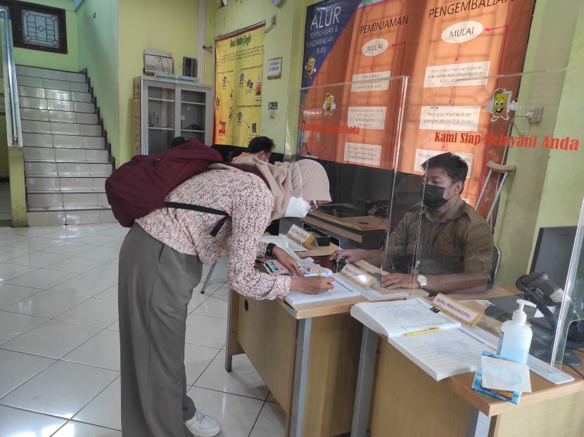 Salah seorang pengunjung Pepustakaan Kota Yogyakarta mengisi buku hadir. 