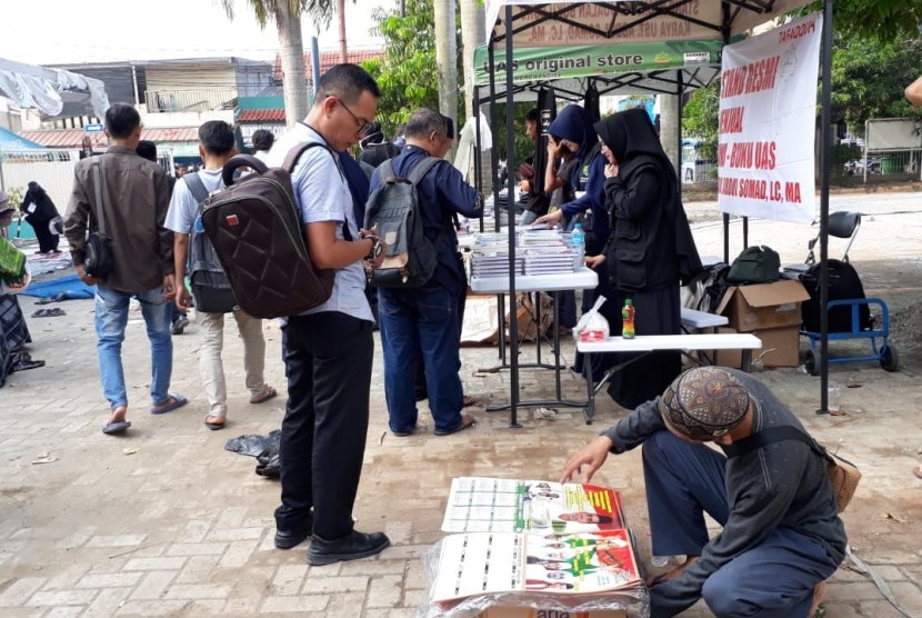 Salah seorang penjual, Firdaus, tengah menjajakan cinderamata Ustaz Abdul somad kepada jamaah yang menghadiri tausiyah UAS di kampus UNIS, Kota Tangerang, Kamis (1/11). Ia mengaku meraup berkah dari berjualan cinderamata UAS tersebut. 