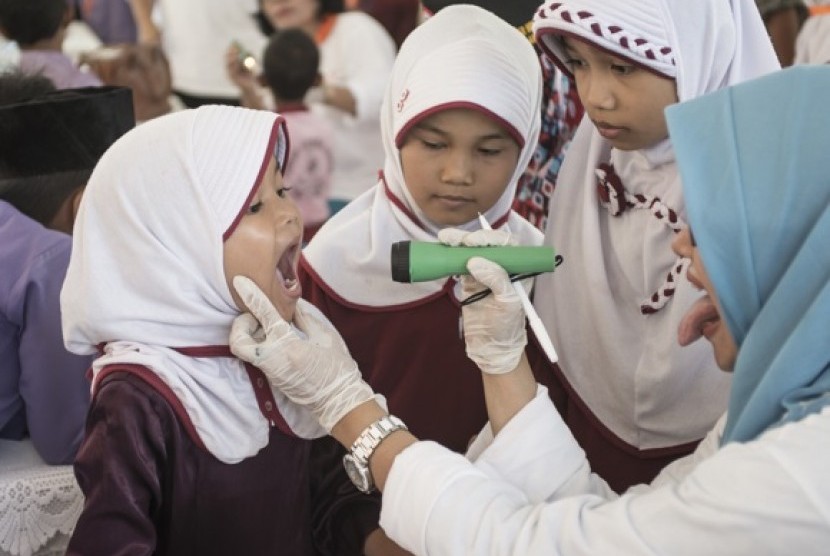 Salah seorang peserta Japfa4Kids sedang diperiksa kesehatan gigi dan mulutnya oleh petugas Puskesmas Tambang.