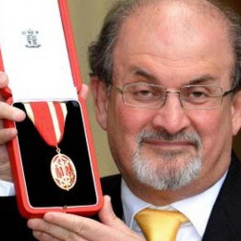 Salman Rushdie memamerkan medali dari Ratu Inggris yang membuat dia menyandang gelar bangsawan: Sir.