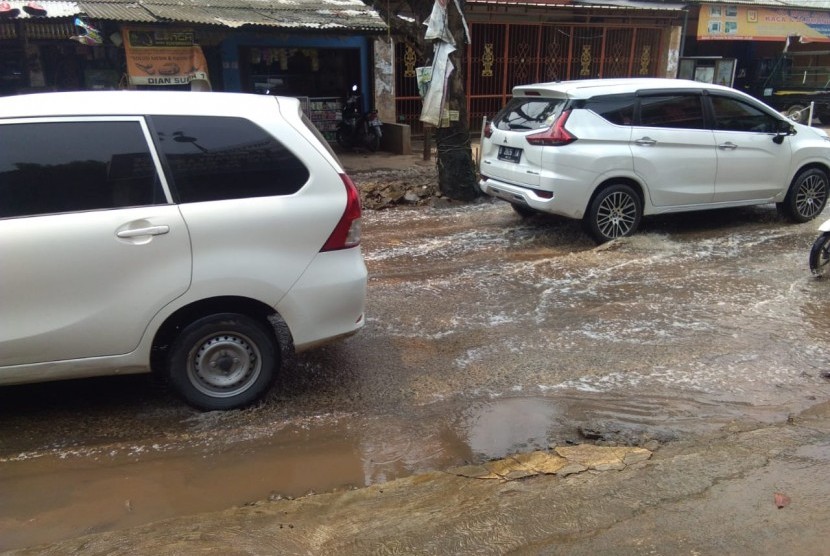 Saluran air tersumbat di Jalan Raya Parpostel,  Jatiasih,  Kota Bekasi mengakibatkan air selokan menggenang ke tengah jalan.
