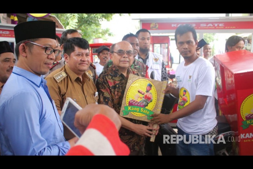 Ketua BAZNAS RI,  Bambang Sudibyo menerima kipas angin Kang Sate saat meresmikan lembaga Pemberdayaan Ekonomi Mustahik (LPEM) meresmikan kelompok usaha sate yang diberi nama Gartim Setia Rasa di Kecamatan Cabangbungin, Kabupaten Bekasi, Senin (17/2). 