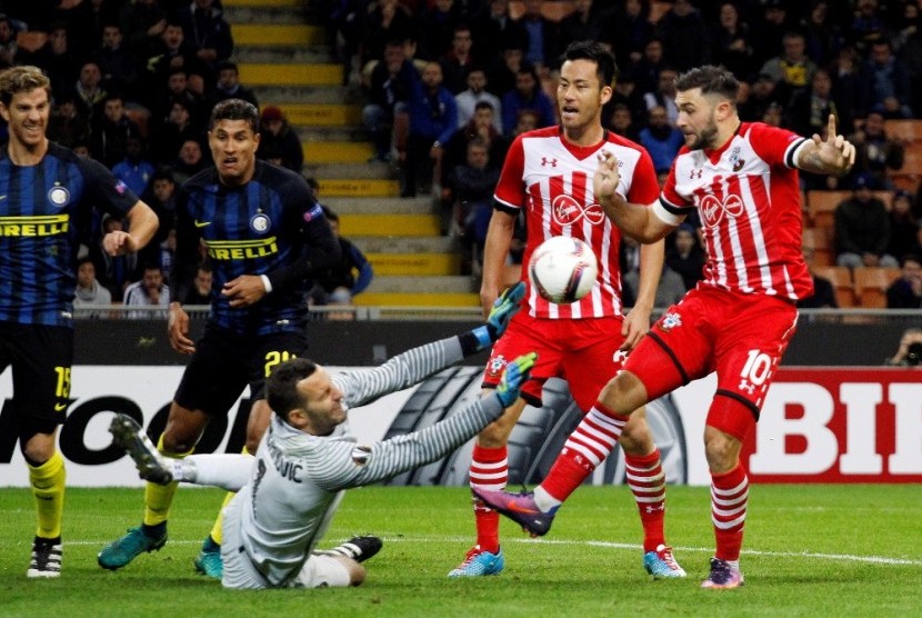 Samir Handanovic (bawah) menjatuhkan badan untuk mencegah bola masuk ke gawangnya.