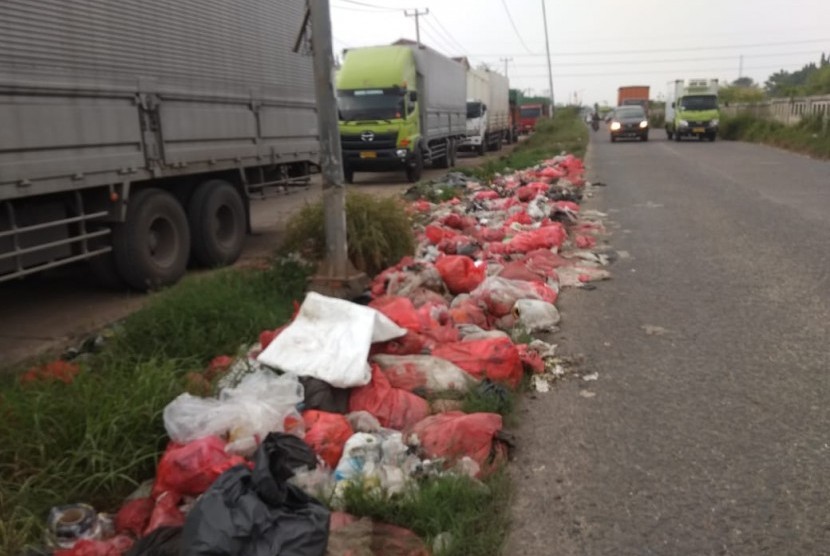 Sampah menumpuk disepanjang jalan Inspeksi Kalimalang,  Cikarang Barat, Kabupaten Bekasi,  Senin (20/5)