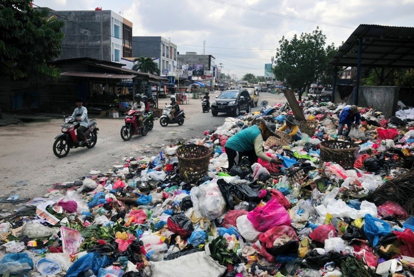 Sampah menumpuk memenuhi badan jalan di Jalan Rajawali, Kota Pekanbaru, Selasa (7/6). Tumpukan sampah kini banyak ditemukan di sudut Kota Pekanbaru setelah upaya pemerintah daerah untuk menswastanisasi layanan angkut sampah melalui PT Multi Inti Guna (MIG)