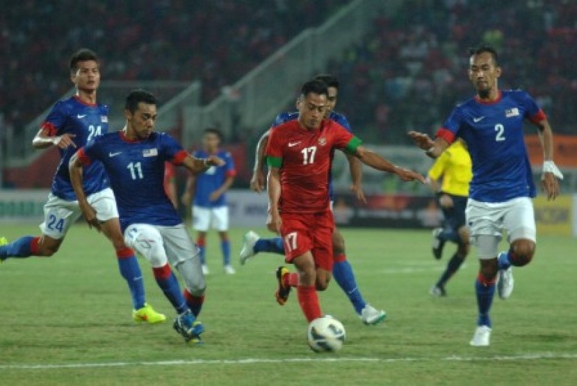 Samsul Arif dijaga para pemain Malaysia dalam laga uji coba di Stadion Gelora Delta Sidoarjo, Ahad (14/9).