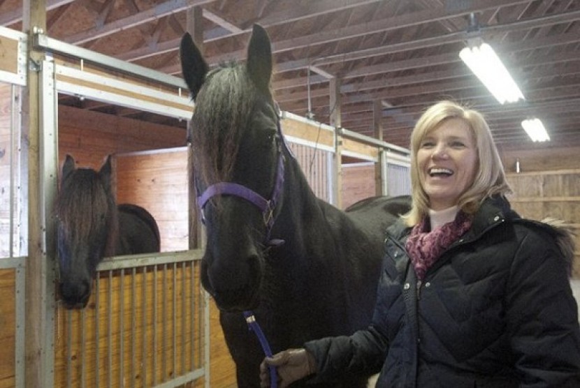 Sandy Bonem, right, holds her horse Mariska, in her stable at Larkin Township, Mich. in Midland County on Feb. 13, 2013. 