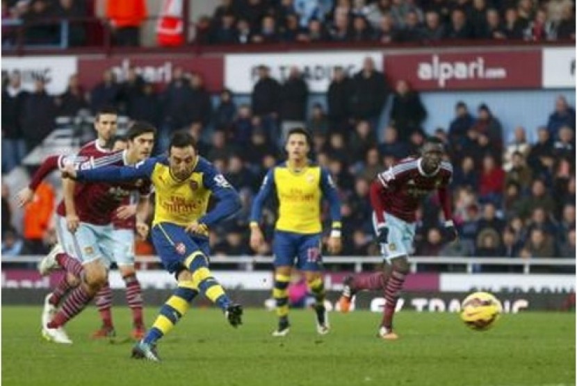 Santi Cazorla saat mencetak gol ke gawang West Ham United lewat tendangan penalti, Ahad (28/12).