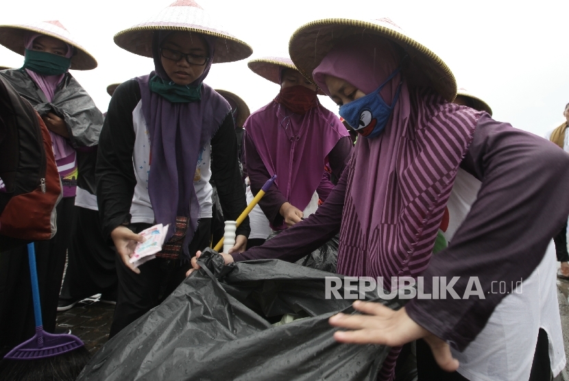 Santri asal Ciamis membersihkan sampah yang tertinggal usai berlangsungnya aksi Super Damai 212 di kawasan silang Monas, Jakarta, Jumat (2/12).
