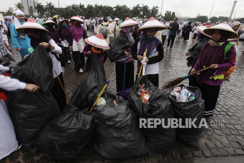 Santri asal Ciamis membersihkan sampah yang tertinggal usai berlangsungnya aksi Super Damai 212 di kawasan silang Monas,Jakarta, Jumat (2/12).