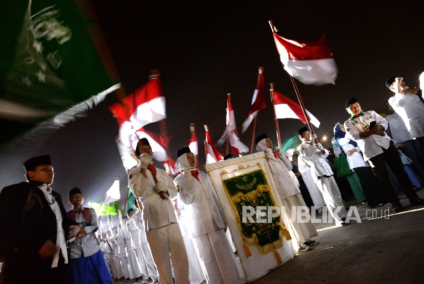 Santri membawa Pataka NU dan Bendera Merah Putih saat kirab peringatan Hari Santri Nasional di Masjid Raya KH Hasyim Asyari, Jakarta, Sabtu (21/10) malam.