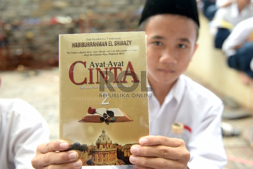 Santri menunjukan buku Ayat-Ayat Cinta 2 saat peluncuran perdana di Pondok Pesantren Modern Ummul Quro Al-Islami di Lewiliang, Bogor, Jawa Barat, Kamis (26/11). (Republika/Wihdan)