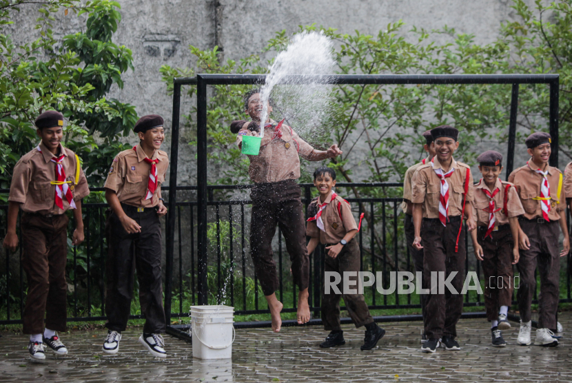 Santri menyiramkan air saat mengikuti kegiatan pramuka di Pondok Pesantren Khoirur Roziqiin, Beji, Depok, Jawa Barat, Sabtu (2/3/2024). Akses jalan pondok pesantren yang bersebelahan dengan komplek perumahan Caltex tersebut ditutup dari segala arah sehingga para santri harus menaiki tangga untuk mengambil logistik makanan atau apabila ingin beraktivitas diluar lingkungan pesantren. Ketua Yayasan Pondok Pesantren Khoirur Roziqiin, Ali Murtadho berharap Pemerintah Kota Depok selaku yang memiliki wewenang pada jalan fasilitas umum tersebut untuk memberi solusi bagi kedua belah pihak dan membongkar pagar yang menutup akses jalan masuk pondok pesantren.