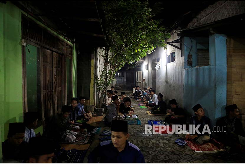 Santri Pesantren Lirboyo Kediri, Jawa Timur mempelajari Kitab Kuning di luar ruang pesantren pada bulan Ramadhan.