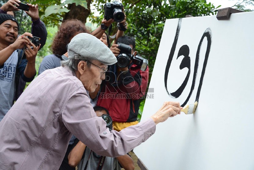   Sapardi Djoko Damono melukis kaligrafi dan aksara Jawa pada pembukaan pameran lukisan dan puisi 'Lima Rukun' di Studio Jeihan, Bandung, Sabtu (28/9). (Republika/Edi Yusuf)