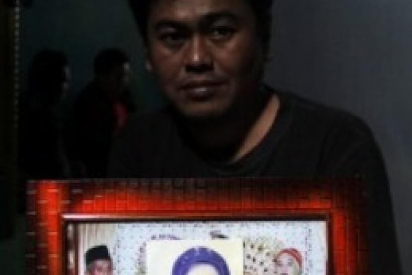 Saparuddin (36) menunjukkan foto keluarganya yang menjadi korban tertimpa crane di Arab Saudi, di rumahnya, di kecamatan Somba Opu, Kabupaten Gowa, Sulawesi Selatan, Sabtu (12/9).