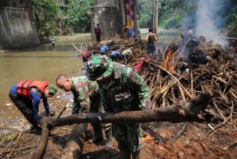 Satgas Banjir dari Dinas Bina Marga dan Sumber Daya Air Kota Depok bersama anggota Kodim 0508 membersihkan tumpukan sampah dan material kayu yang menghambat aliran sungai  (ilustrasi) 