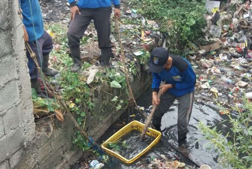 Petugas sedang membersihkan sampah yang berserakan akibat banjir (ilustrasi)