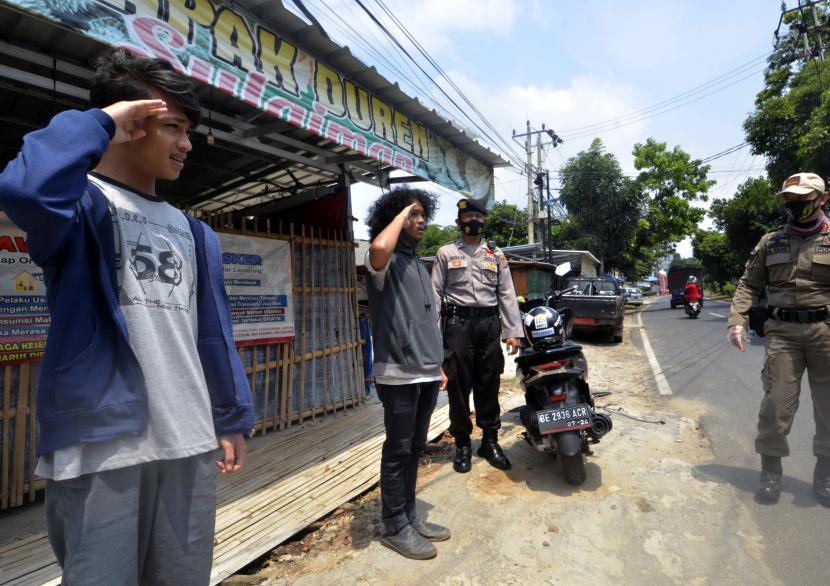 Satgas gabungan memberi sanksi kepada warga yang tidak mengenakan masker saat razia yustisi protokol kesehatan, di Bandar Lampung, Lampung, Rabu (23/9/2020). Operasi Yustisi tersebut untuk menertibkan masyarakat agar disiplin menerapkan protokol kesehatan guna mencegah penyebaran COVID-19 menyusul semakin meningkatnya kasus positif COVID-19 di Lampung. 