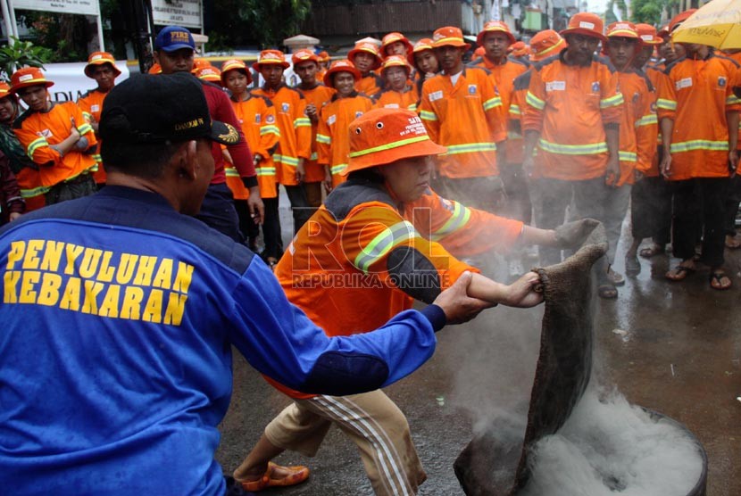  Satgas Kebakaran tengah berlatih menangani kebakaran di halaman Kelurahan Pekojan, Tambora, Jakarta Barat, Ahad (22/12).  (Republika/Yasin Habibi)