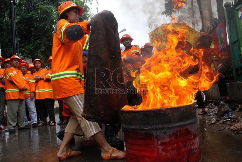  Satgas Kebakaran tengah berlatih menangani kebakaran di halaman Kelurahan Pekojan, Tambora, Jakarta Barat, Ahad (22/12).  (Republika/Yasin Habibi)