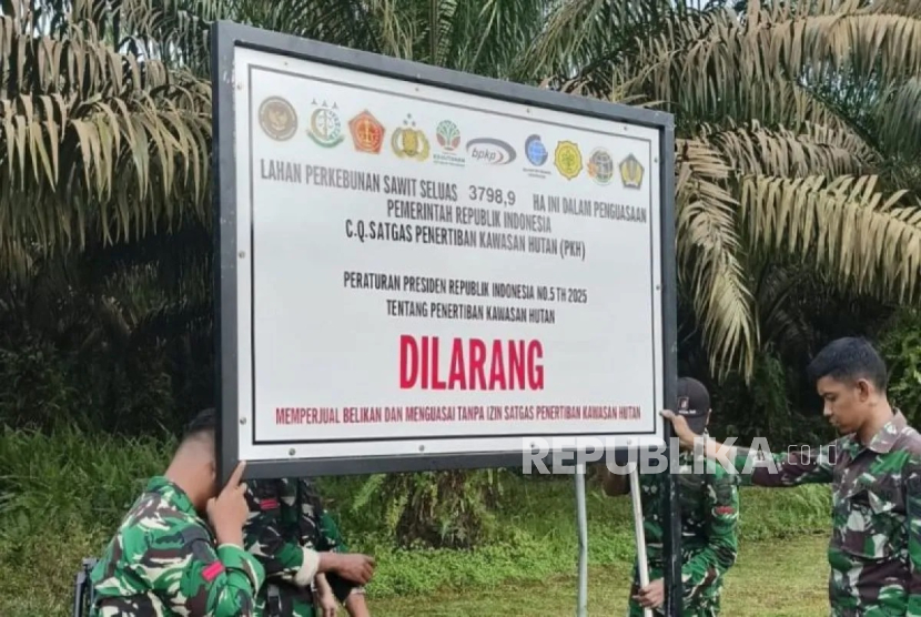 Satgas Penertiban Kawasan Hutan memasang plang di kawasan kebun sawit yang disita untuk negara di Kalimantan.