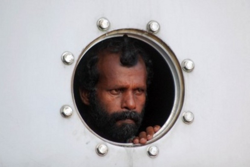 Satu dari sejumlah imigran gelap asal Srilanka yang dievakuasi Tim Basarnas melihat dari jendela kapal saat akan dipindahkan ke daratan, di Pelabuhan Teluk Bayur, Padang, Sumbar, Rabu (2/1/2013)