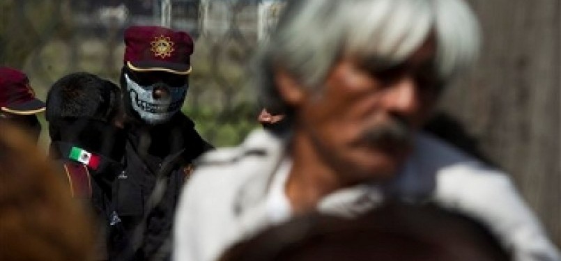 Satu petugas mengenakan topeng berjaga di penjara Apodaca, Meksiko, usai kerusuhan yang mengakibatkan 44 napi tewas.