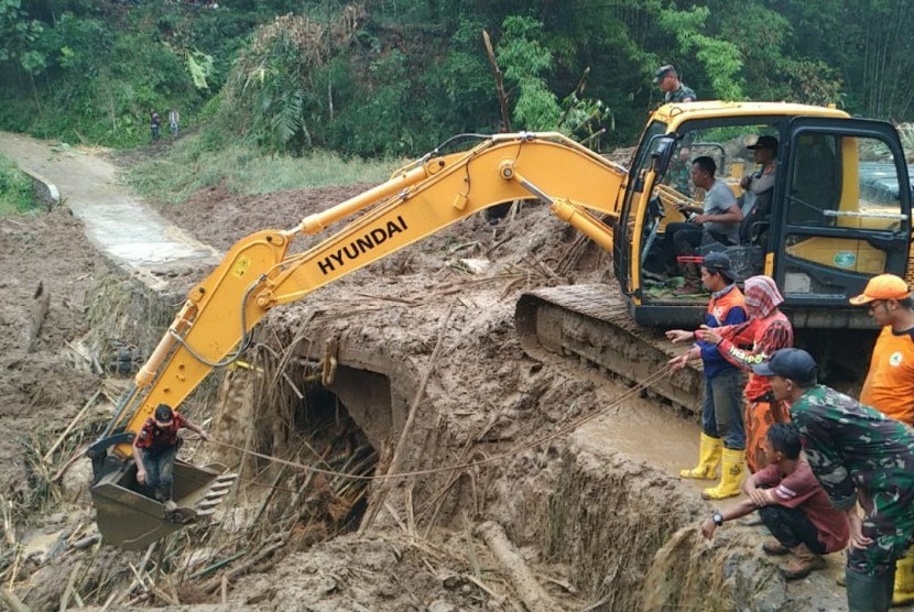Satu unit alat berat dikerahkan untuk membersihkan jembatan yang tertimbun material longsor di Desa Santanamekar, Kecamatan Cisayong, Kabupaten Tasikmalaya, Sabtu (29/2). 