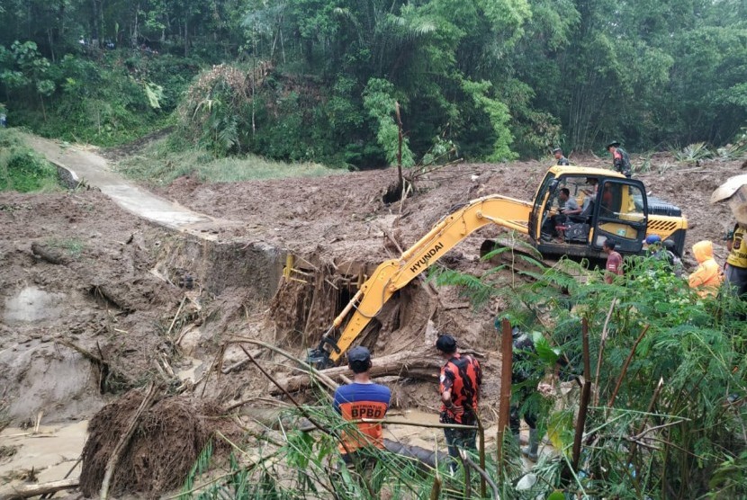 Satu unit alat berat dikerahkan untuk membersihkan jembatan yang tertimbun material longsor di Desa Santanamekar, Kecamatan Cisayong, Kabupaten Tasikmalaya, Sabtu (29/2).