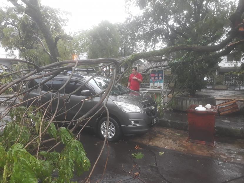 Satu unit kendaraan roda empat di Jalan Baros, Cihapit Kota Bandung tertimpa pohon tumbang, Rabu (10/11). Hujan deras mengakibatkan sejumlah wilayah terendam banjir dan pohon tumbang.