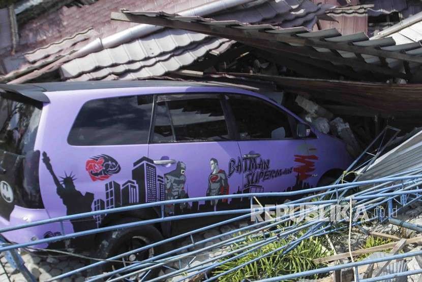 Satu unit kendaraan tertimpa bagian bangunan rumah akibat gempa 7,4 pada skala richter (SR), di kawasan Kampung Petobo, Palu, Sulawesi Tengah, Selasa (2/10).